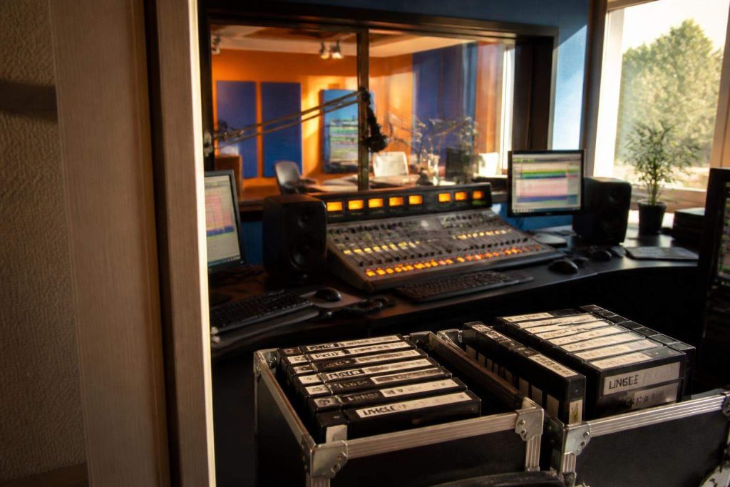 Consola de radio con cartuchos etiquetados como jingle y liner en una cabina de emisión